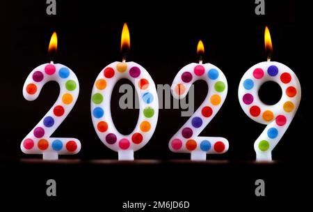 Farbige Kerzen schreiben Zahlen Flamme Frohes neues Jahr 2029 Stockfoto