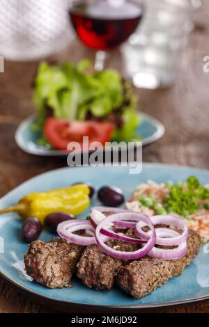 Cevapcici mit Djuvec-Reis auf Holz Stockfoto