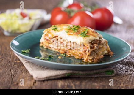 Portion Lasagne auf einem grünen Teller Stockfoto