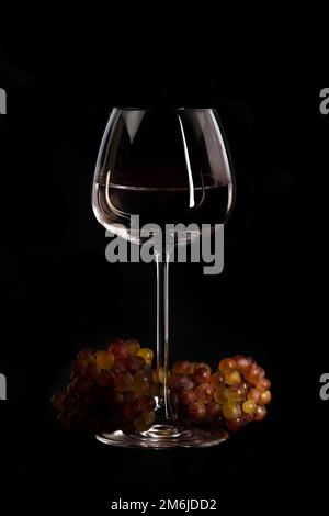 Ambiente mit frischen Trauben und Wein im Glas Stockfoto