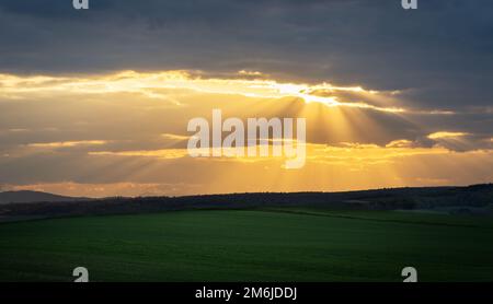 Sonnenstrahlen auf einer Wolkenlücke im Burgenland Stockfoto