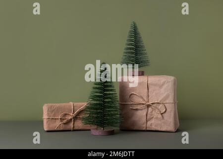 Kleiner dekorativer grüner weihnachtsbaum auf grünem Hintergrund. Weihnachtskarte mit einem Platz für eine Inschrift. Wunderschönes festliches B Stockfoto