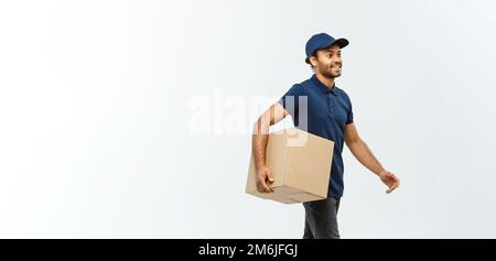 Lieferkonzept - Portrait Of Happy African American Delivery man in Blue Cloth Walking, um dem Kunden ein Paketpaket zu schicken. Isol Stockfoto