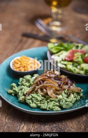 Bayerischer Spinatspaetzle auf Holz Stockfoto