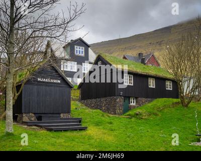 Traditionelle Häuser mit schwarz getarnten Holzwänden und Rasendach in Fuglafjørður Stockfoto