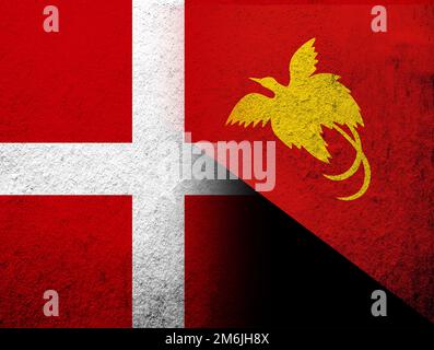 Die Nationalflagge des Königreichs Dänemark mit der Nationalflagge des unabhängigen Staates Papua-Neuguinea. Grunge Hintergrund Stockfoto