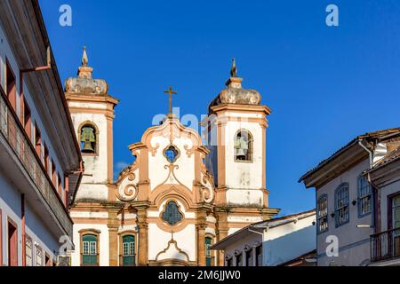 Fassade eines historischen Hauses im Kolonialstil und einer Kirche in Ouro Preto Stockfoto