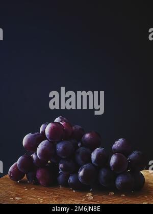 Reife, saftige dunkle Trauben auf Holzschreibtisch, Essen und Wein, Bio-Früchte Stockfoto