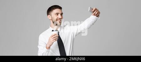 Lifestyle und Business Concept - Portrait eines gutaussehenden Geschäftsmannes genießen Sie es, eine selfie mit einer Tasse Kaffee zu sich zu nehmen. Isoliert Stockfoto