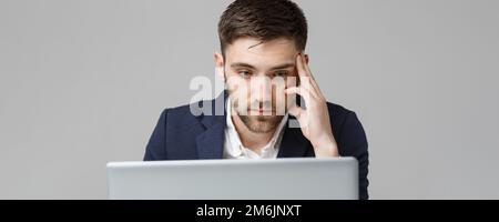 Geschäftskonzept - Porträt schön Ernst Mann im Anzug am Laptop. Weißer Hintergrund. Stockfoto