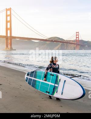 Frau mit Paddleboard, die in Richtung Golden Gate Bridge geht Stockfoto