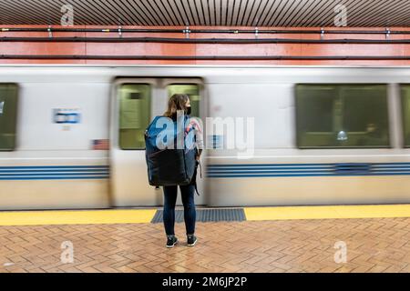 Rückansicht einer Frau mit Tasche vor der U-Bahn Stockfoto