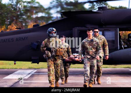 Grafenwoehr, Bayern, Deutschland. 3. November 2022. Soldaten, die der Task Force Orion, dem 27. Infanterie-Brigade-Kampfteam, der New Yorker Armee-Nationalgarde, der 12. Kampfluftfahrtbrigade und dem Joint Multinational Readiness Center zugeteilt sind, tragen während einer medizinischen Evakuierungsprüfung in Grafenwoehr, Deutschland, am 3. November 2022 eine militärische Übungspuppe von einem UH-60 Black Hawk-Hubschrauber weg. Die Task Force Orion unterstützt seit August 2022 die Mission der Joint Multinational Training Group ''' Ukraine, um die Kampffektivität der ukrainischen Militärausbildung in Systemen und eq zu gewährleisten Stockfoto