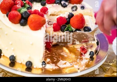 Eine Frau schneidet Kuchen Stockfoto