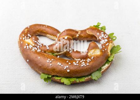 Bayerische Brezel mit Petersilie auf Weiß Stockfoto