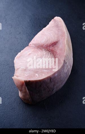 Rohes Schwertfischsteak wird als Nahaufnahme auf einem schwarzen Brett mit Kopierbereich angeboten Stockfoto