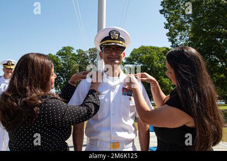 PORTSMOUTH, VA (30. April 2022) - Konteradmiral Guido Valdes, der der Naval Medical Forces Atlantic zugeteilt ist, lächelt, während seine Schwestern Anna und Maria seine Schulterbretter ersetzen, während seiner Frockzeremonie am 30. April 2022. Naval Medical Forces Atlantic stellt gut ausgebildete medizinische Experten bereit, die als Hochleistungsteams agieren, um medizinische Macht zur Unterstützung der Überlegenheit der Marine zu projizieren. Stockfoto