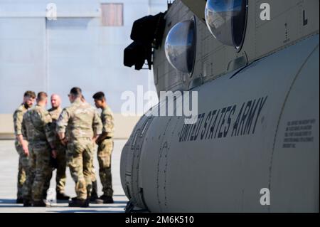 Royal Air Force-Flieger warten vor den USA Army CH-47 Chinook, der B-Kompanie zugeteilt, 1. Bataillon, 52. Luftfahrtregiment während RED FLAG-Alaska 22-1 auf dem Luftwaffenstützpunkt Eielson, Alaska, 29. April 2022. Diese Übung bietet einzigartige Möglichkeiten zur Integration verschiedener Kräfte in gemeinsame und multilaterale Schulungen von simulierten Operationsbasen. Stockfoto