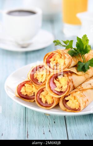 Hausgemachte dünne Pfannkuchen mit einer Scheibe Schinken und Rührei Stockfoto