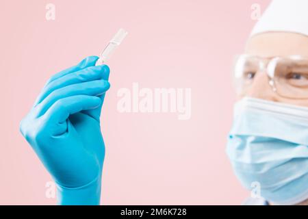 Arzt, der eine Viol mit Impfstoff gegen Corona-Virus hält. Stockfoto