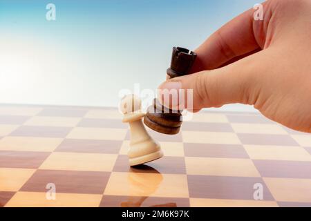 Person, die ein Schachspiel spielt und einen Zug macht Stockfoto
