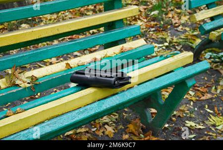 Handtasche auf einer Bank im Park Stockfoto