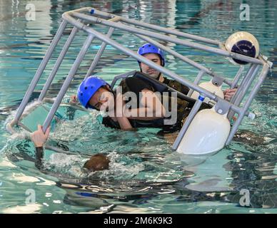 Soldaten, die dem 3. Bataillon der New York Army National Guard 142. Aviation Regiment zugeteilt sind, lernen im Fort Drum, New Yorks simuliertem Wasserentlassungstraining im McGrath Sports Complex am 29. April 2022, wie man einen Wasserunfall überlebt. Das Bataillon führte von April 23 bis Mai 7 eine jährliche Ausbildung in Fort Drum durch, während sie sich auf die Mobilisierung und den Einsatz nach Kuwait im Juni vorbereiteten. (USA Geburtsort: A) Bezirk Kandahar, Provinz Kandahar, Afghanistan. Stockfoto