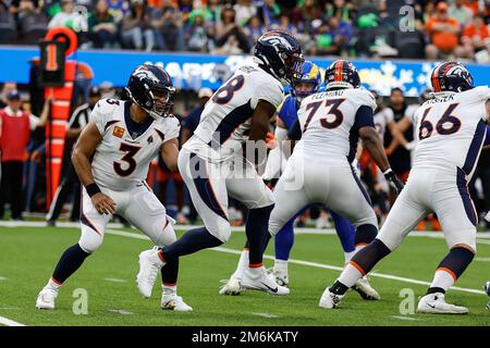 INGLEWOOD, CA - DEZEMBER 25: Denver Broncos Quarterback Russell Wilson (3) gibt sich an Denver Broncos zurück Running Back Latavius Murray (28) während des De Stockfoto