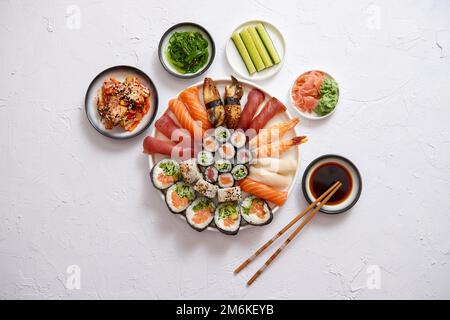 Verschiedene sushi Rollen auf runden keramischen Platte positioniert Stockfoto