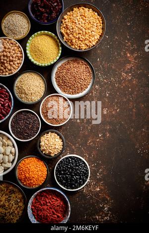 Verschiedene superfoods in kleinen Schüsseln auf dunklen Rusty Hintergrund Stockfoto