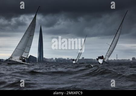 Russland, St. Petersburg, 17. Juni 2022: Teamwork in Segelregatta bei Sturmwetter, Wolkenkratzer Lakhta Zentrum des Gasunternehmens Gazp Stockfoto