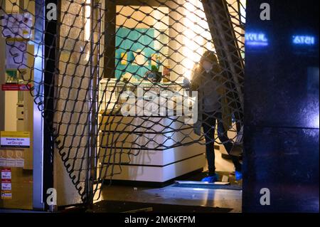 Hamburg, Deutschland. 05. Januar 2023. Ein Ermittler der Kriminalpolizei sucht in einem Pfandhaus nach Hinweisen. Ein Auto ist gegen eine Pfandleihe im Hamburger Stadtteil Harburg gefahren. Der oder die Täter sind auf der Flucht, sagte eine Polizeisprecherin. Kredit: Jonas Walzberg/dpa/Alamy Live News Stockfoto