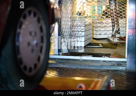 Hamburg, Deutschland. 05. Januar 2023. Der Reifen eines Fahrzeugs vor dem zerstörten Eingang einer Pfandleihe. Ein Auto ist gegen eine Pfandleihe im Hamburger Stadtteil Harburg gefahren. Der oder die Täter sind auf der Flucht, sagte eine Polizeisprecherin. Kredit: Jonas Walzberg/dpa/Alamy Live News Stockfoto