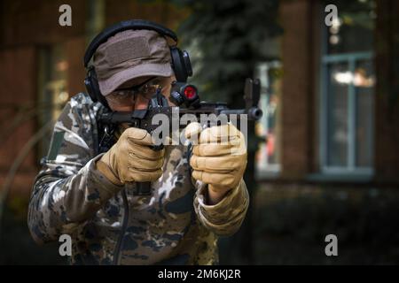 Taktischer Trainingskurs, junger Mann. Schießstand im Freien. Schrotflinten-Aktionskurs. Privater militärischer Auftragnehmer bei Tactica Stockfoto