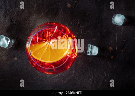 Aperol Cocktail mit einer Orangenscheibe und Eiswürfeln aus der Nähe, italienisches Getränk Stockfoto