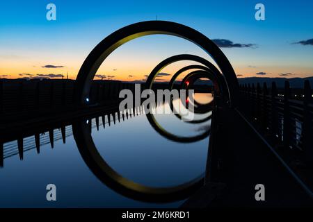 Blick auf das Falkirk Wheel bei Sonnenuntergang mit Lichtern in verschiedenen hellen Farben Stockfoto