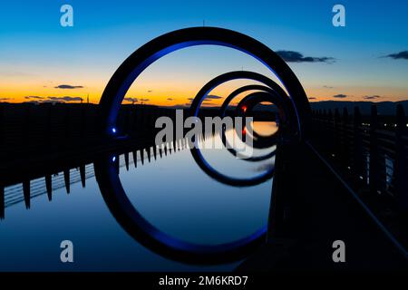 Blick auf das Falkirk Wheel bei Sonnenuntergang mit Lichtern in verschiedenen hellen Farben Stockfoto