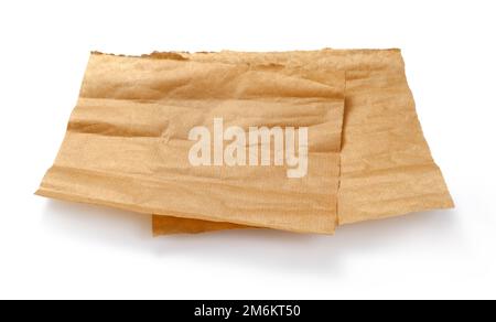 Backpapier isoliert. Zerknitterte Stücke braunes Pergament oder Backpapier auf weißem Hintergrund. Konstruktionselement. Stockfoto
