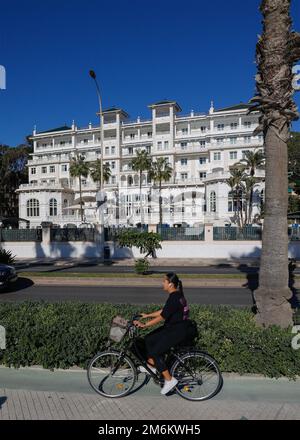 Radfahrerin auf dem Radweg mit dem Hotel Gran Miramar im Hintergrund, Malaga, Spanien, Europa. Stockfoto