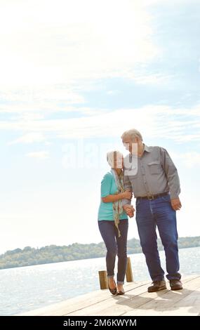 Ich fühle mich wieder wie Teenager. Ein Seniorenpaar, das am Steg entlang läuft. Stockfoto