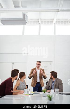 Seine Mitarbeiter mit Erfahrung zu führen. Eine Gruppe von Geschäftsleuten im Sitzungssaal. Stockfoto