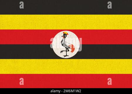 Flagge Ugandas. Ugandische Flagge auf Stoffoberfläche. Stoffstruktur. Nationales Symbol Ugandas auf Muster Stockfoto