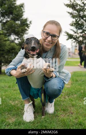 Eine Frau, die draußen mit einem Bullenterrier läuft Stockfoto