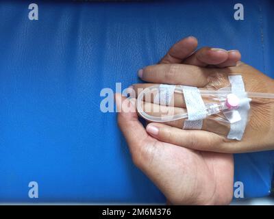 Halten der Infusionshand im Krankenhaus zur Unterstützung Stockfoto