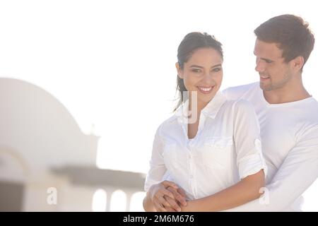 Immer glücklich in seinen Armen. Ein attraktives junges Paar in Weiß. Stockfoto