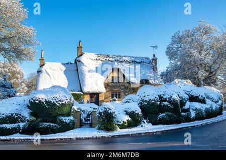 Strohgedeckte Hütte im Schnee im Dezember. Chipping Campden, Cotswolds, Gloucestershire, England Stockfoto