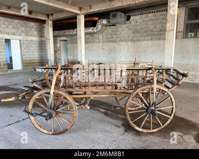 Holzwagen auf Rädern steht in der Garage Stockfoto