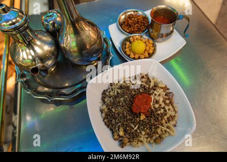 Koshary, Kushari oder Koshari das beliebteste kulinarische Gericht in Ägypten, eine Mischung aus Nudeln, Reis, Linsen, Kichererbsen und gebratenen Zwiebeln, garniert mit Tomaten Stockfoto