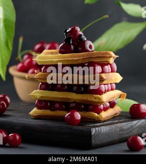 Stapel gebackener belgischer Waffeln mit reifen roten Kirschen Stockfoto