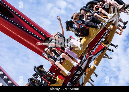 Russland, Sotschi 14.05.2022. Fröhliche Teenager auf einer riesigen runden, extremen Attraktion, die sich zu Vergnügungszwecken bis zum Himmel erhebt Stockfoto